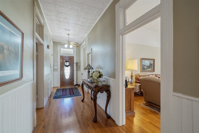 entrance foyer with light wood-type flooring, an ornate ceiling, visible vents, and wainscoting