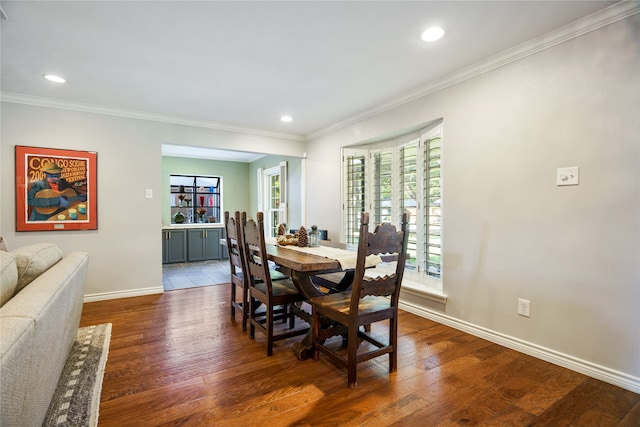 dining area with ornamental molding and dark wood-type flooring