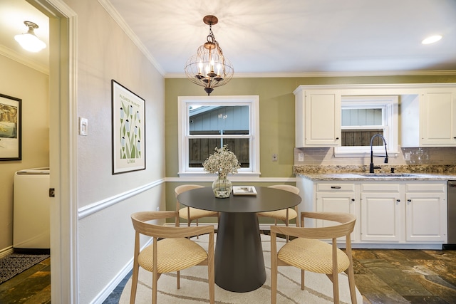 dining space with ornamental molding, sink, and a chandelier