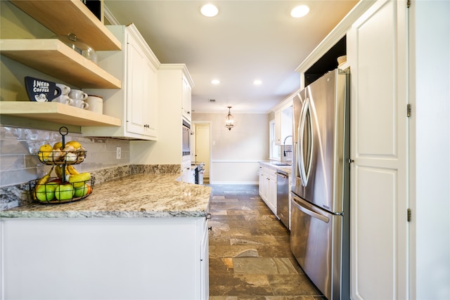 kitchen featuring white cabinets, decorative backsplash, light stone counters, and stainless steel appliances