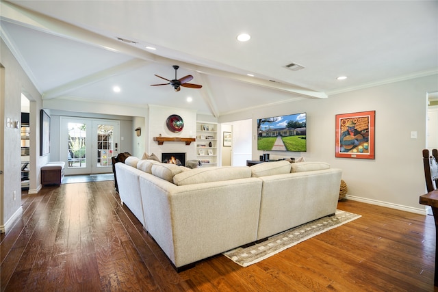 living room featuring ceiling fan, dark wood-type flooring, lofted ceiling with beams, a fireplace, and ornamental molding