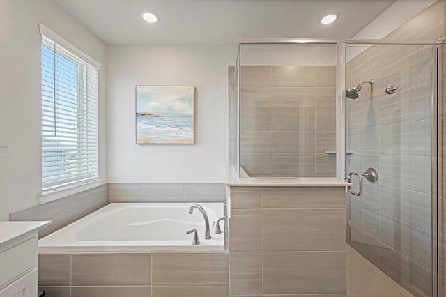 bathroom with a wealth of natural light, vanity, and shower with separate bathtub