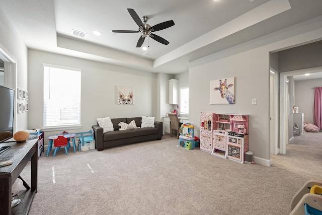 interior space with a raised ceiling, a wealth of natural light, and ceiling fan