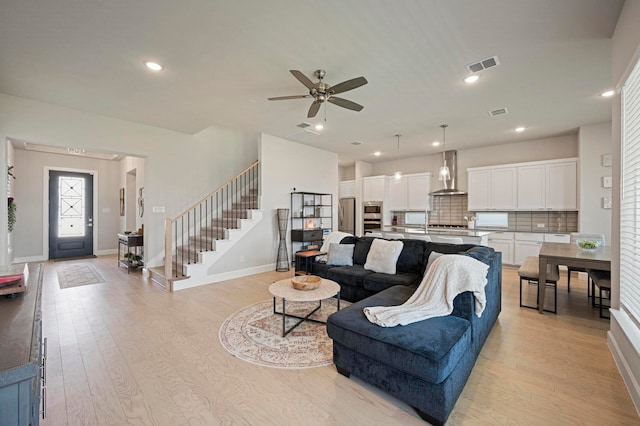 living room featuring ceiling fan and light hardwood / wood-style floors