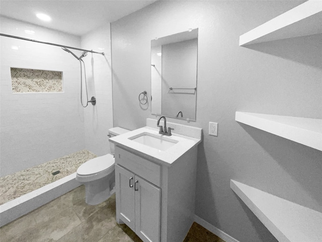 bathroom with tile patterned floors, vanity, toilet, and tiled shower