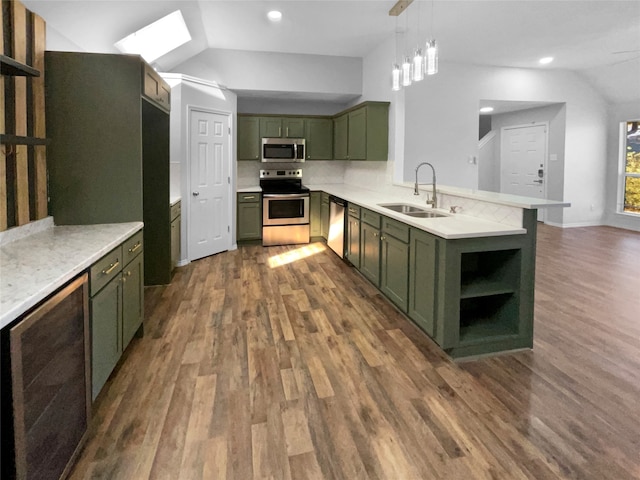 kitchen with sink, green cabinetry, vaulted ceiling, dark hardwood / wood-style floors, and appliances with stainless steel finishes