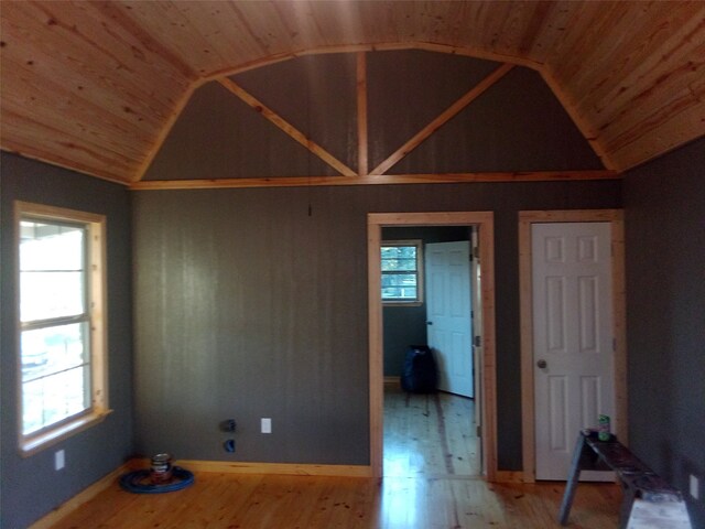 empty room with hardwood / wood-style floors, wooden ceiling, and lofted ceiling