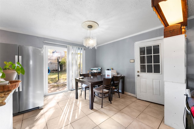 dining room with a textured ceiling, light tile patterned flooring, crown molding, and an inviting chandelier