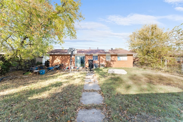 rear view of property with a yard