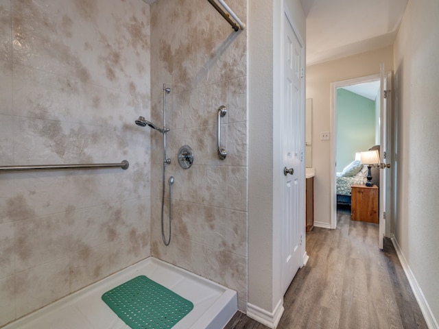 bathroom with wood-type flooring and tiled shower