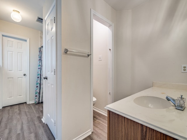 bathroom featuring hardwood / wood-style floors, vanity, and toilet