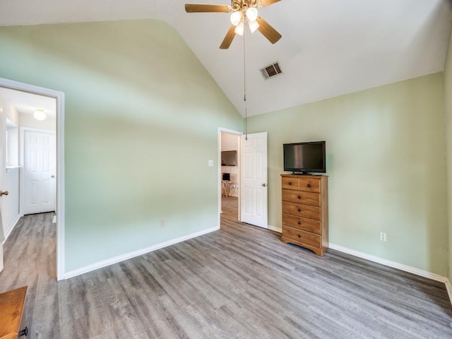 unfurnished bedroom with high vaulted ceiling, wood finished floors, visible vents, and baseboards