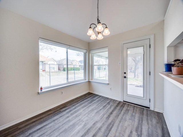 entryway featuring a notable chandelier, baseboards, and wood finished floors