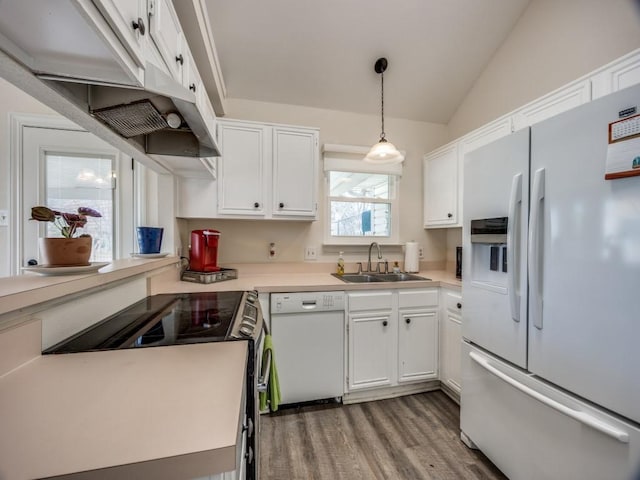 kitchen featuring light countertops, white cabinetry, vaulted ceiling, a sink, and white appliances