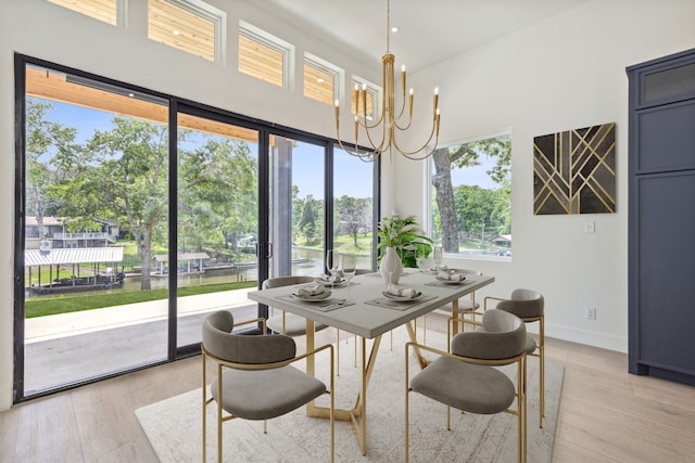 dining space with a healthy amount of sunlight, an inviting chandelier, and light hardwood / wood-style flooring