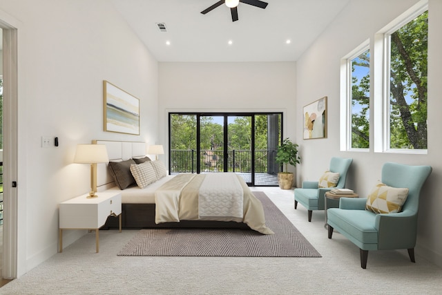 bedroom with light carpet, access to outside, multiple windows, and ceiling fan