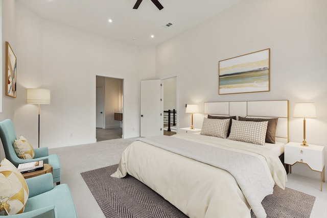 carpeted bedroom with ceiling fan and a towering ceiling