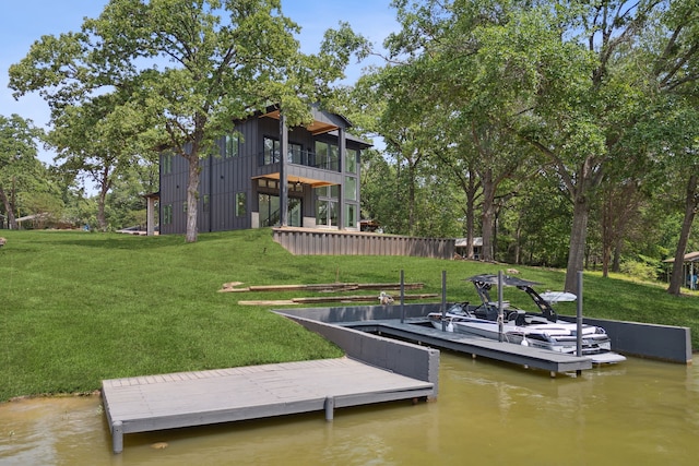 view of dock featuring a lawn, a balcony, and a water view