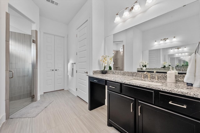 full bathroom featuring a stall shower, a closet, visible vents, and vanity