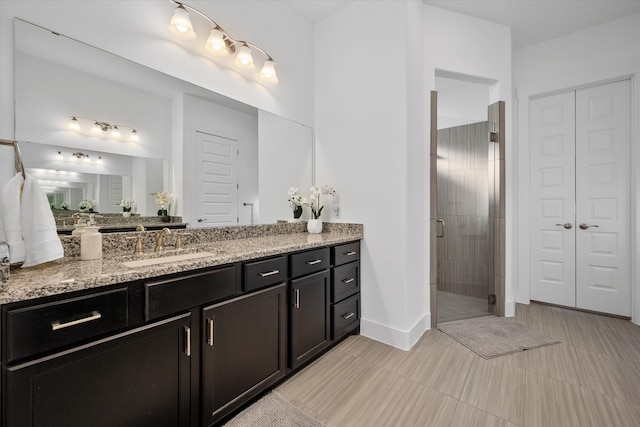 full bathroom featuring a shower stall, baseboards, and vanity