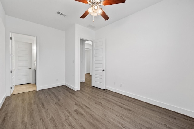 unfurnished bedroom featuring visible vents, baseboards, ceiling fan, and wood finished floors