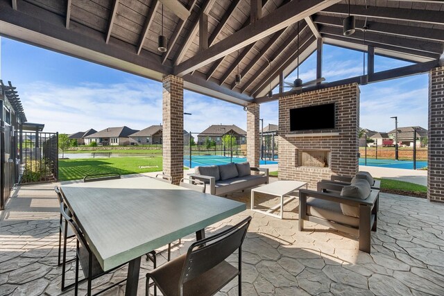 view of patio / terrace featuring a residential view, fence, and an outdoor living space with a fireplace