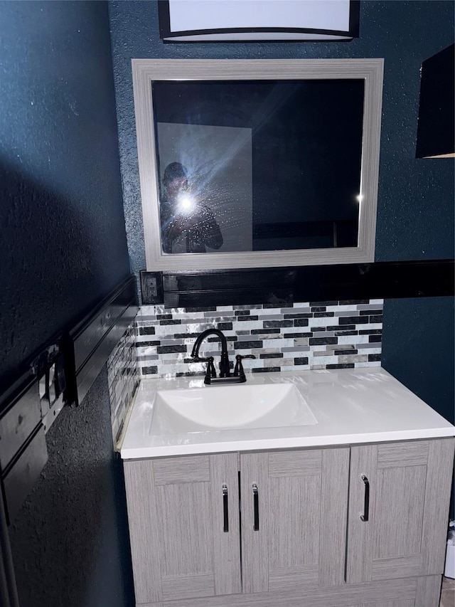 bathroom featuring vanity and decorative backsplash