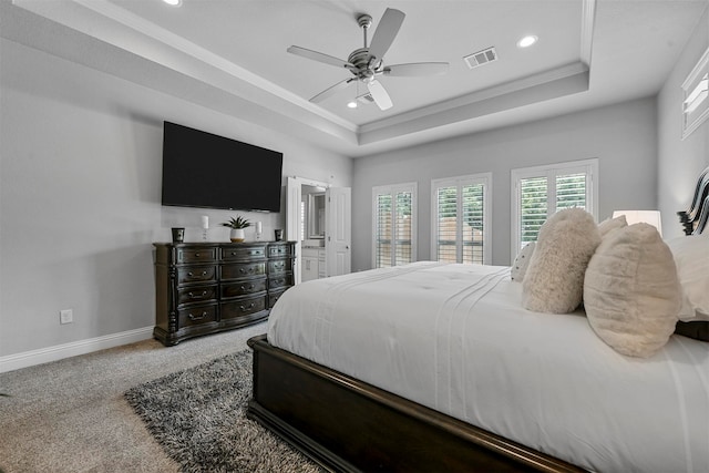 carpeted bedroom with ceiling fan, a raised ceiling, and ornamental molding