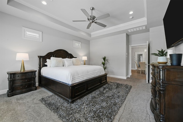 carpeted bedroom with ceiling fan, a raised ceiling, and ornamental molding