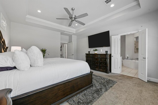 carpeted bedroom featuring ceiling fan, ensuite bath, ornamental molding, and a raised ceiling