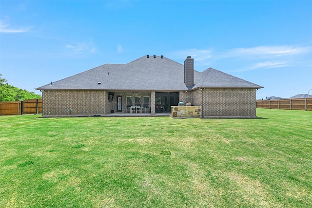 back of house with a patio area and a lawn