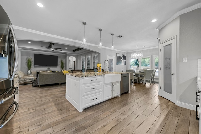 kitchen featuring pendant lighting, stainless steel appliances, white cabinetry, and dark stone countertops