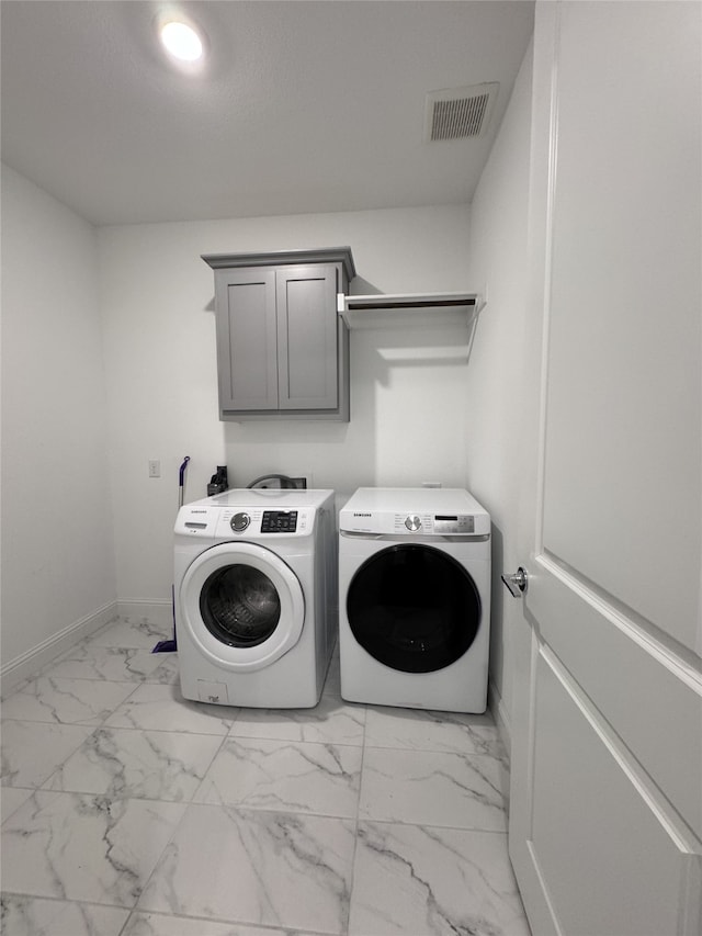 clothes washing area with cabinets and independent washer and dryer