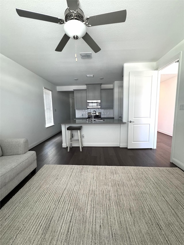 unfurnished living room featuring sink, dark hardwood / wood-style floors, and a textured ceiling