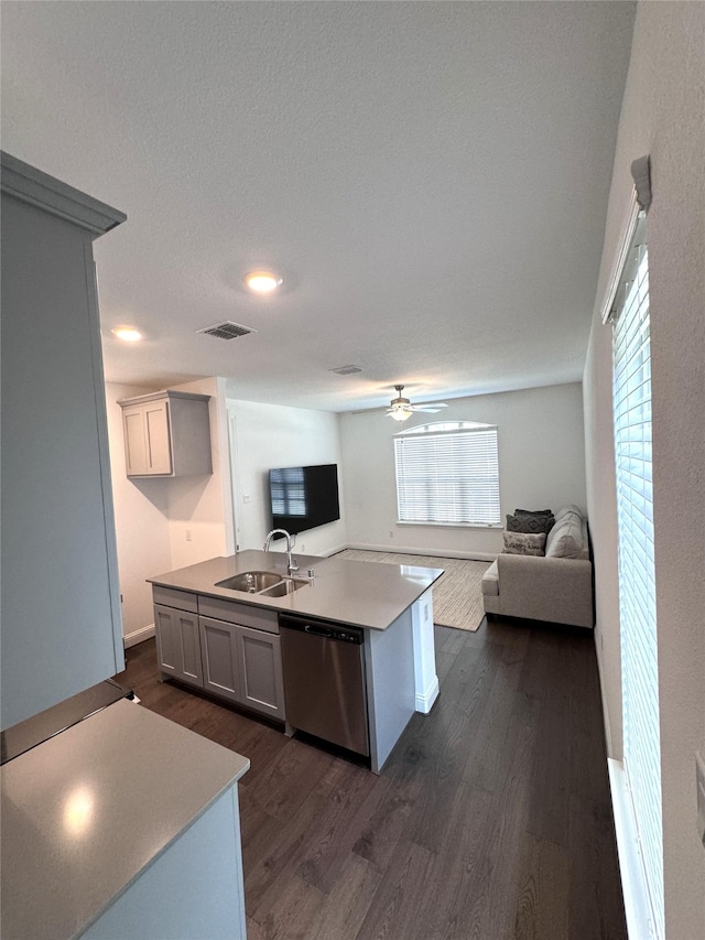 kitchen featuring sink, a center island with sink, dark hardwood / wood-style floors, dishwasher, and ceiling fan