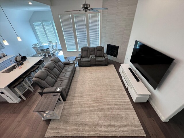 living room with sink, a fireplace, dark hardwood / wood-style floors, and ceiling fan