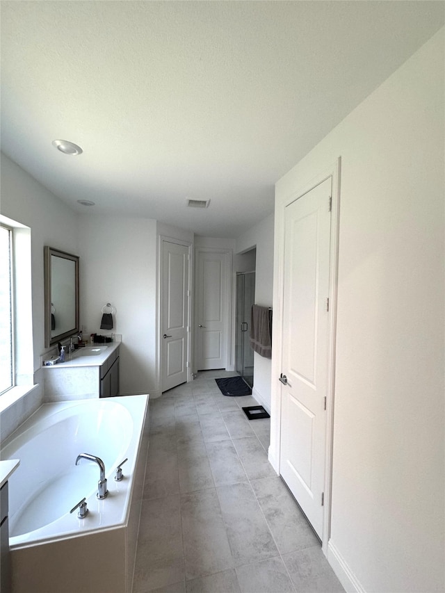 bathroom featuring vanity and a tub to relax in