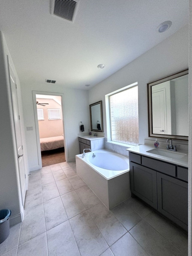 bathroom featuring tile patterned flooring, vanity, and a tub