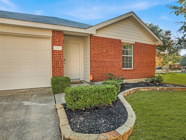 doorway to property with a lawn and a garage