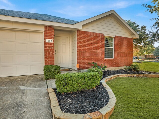 property entrance with a garage and a yard