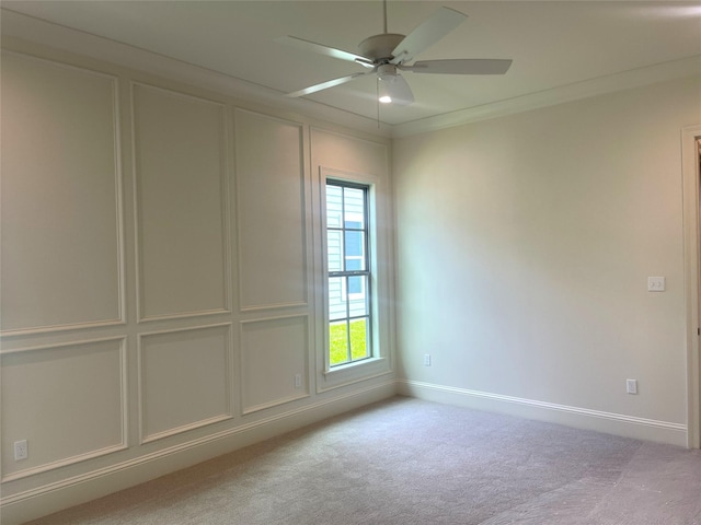 spare room with baseboards, ceiling fan, and light colored carpet