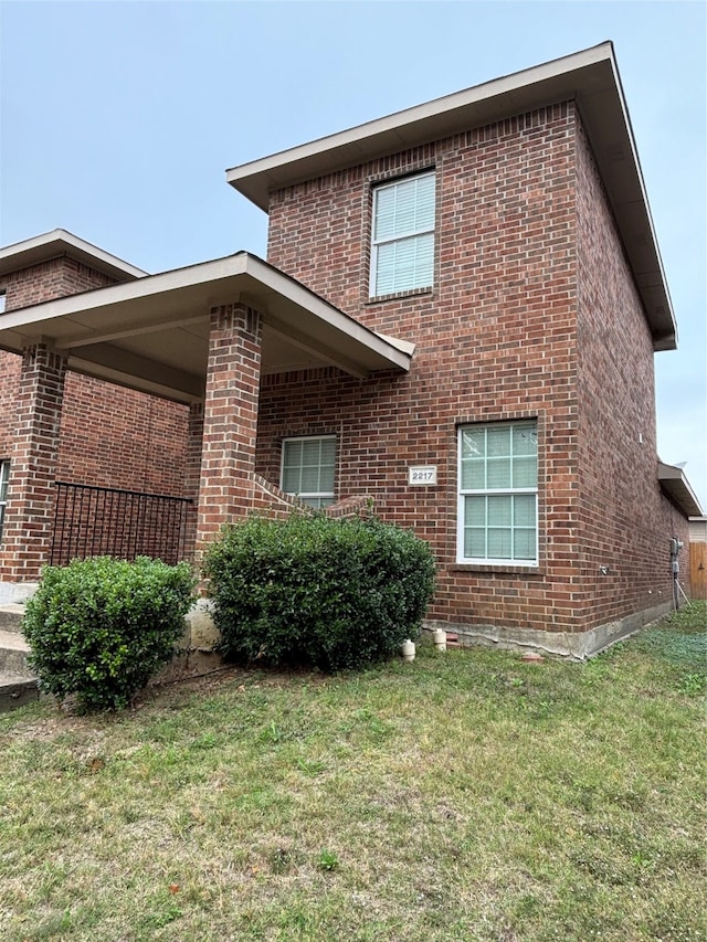 view of side of home with a yard