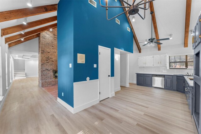 kitchen with beamed ceiling, high vaulted ceiling, white cabinetry, and stainless steel dishwasher