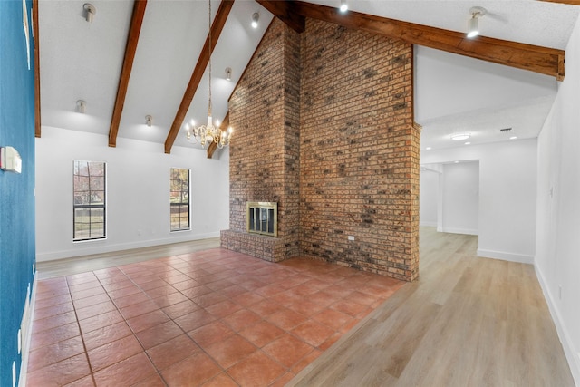 unfurnished living room with hardwood / wood-style floors, high vaulted ceiling, a brick fireplace, and beam ceiling