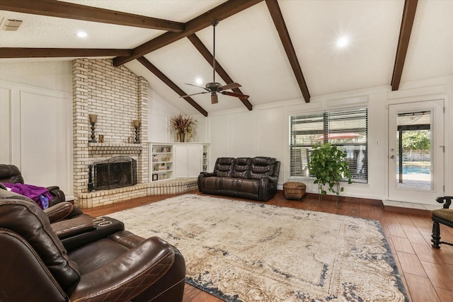 living room with wood finished floors, a decorative wall, a fireplace, and a ceiling fan