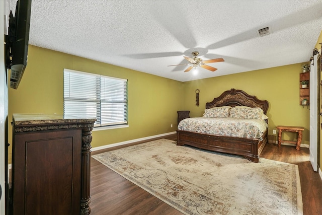 bedroom featuring baseboards, dark wood-style flooring, a textured ceiling, and ceiling fan