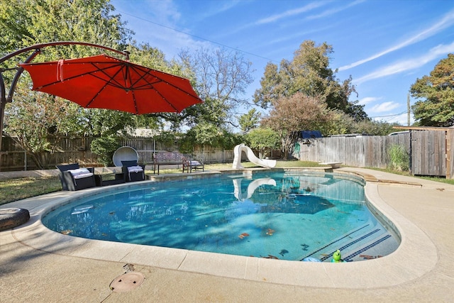 view of swimming pool with a water slide, a fenced backyard, and a patio area