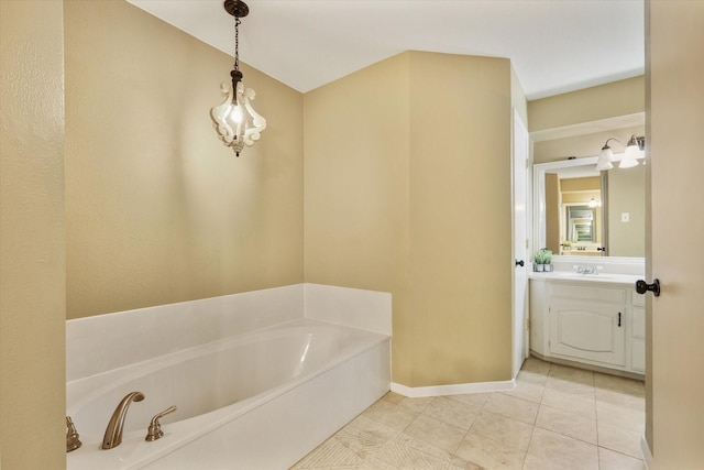 bathroom featuring a garden tub, vanity, tile patterned floors, and baseboards