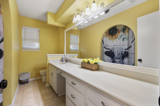full bath with toilet, tile patterned flooring, baseboards, and vanity