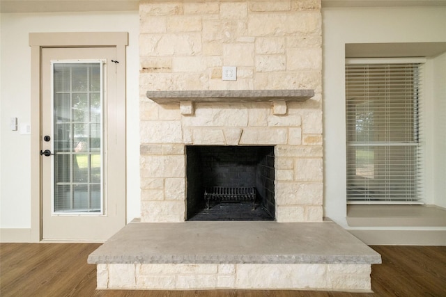 interior details with hardwood / wood-style flooring and a stone fireplace